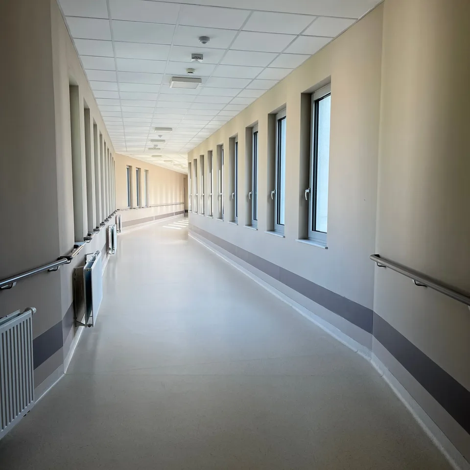 Corridoio ospedaliero illuminato dalla luce naturale, con grandi finestre